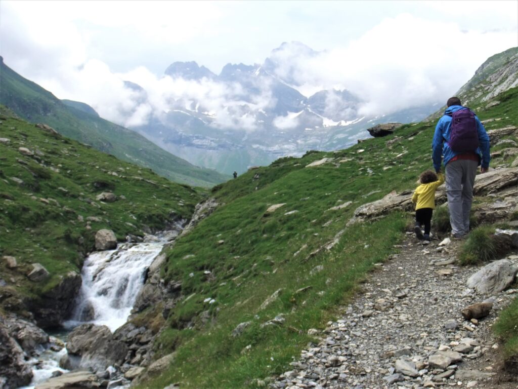 niño de la mano de su padre en la montaña