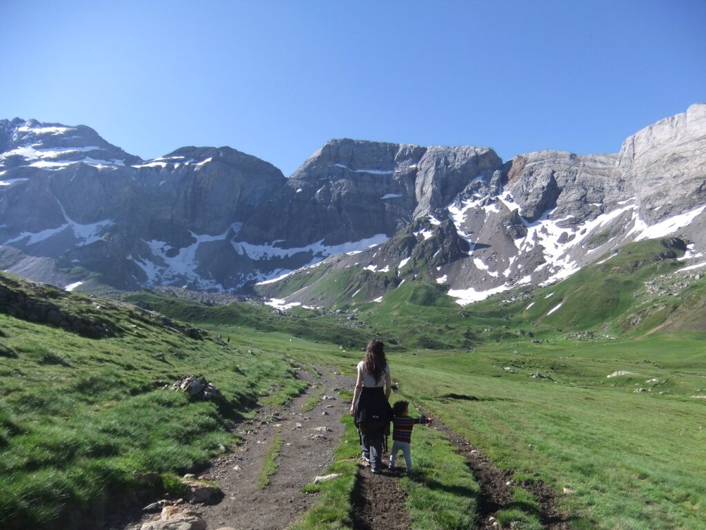 madre andando de la mano de su hijo en alta montaña