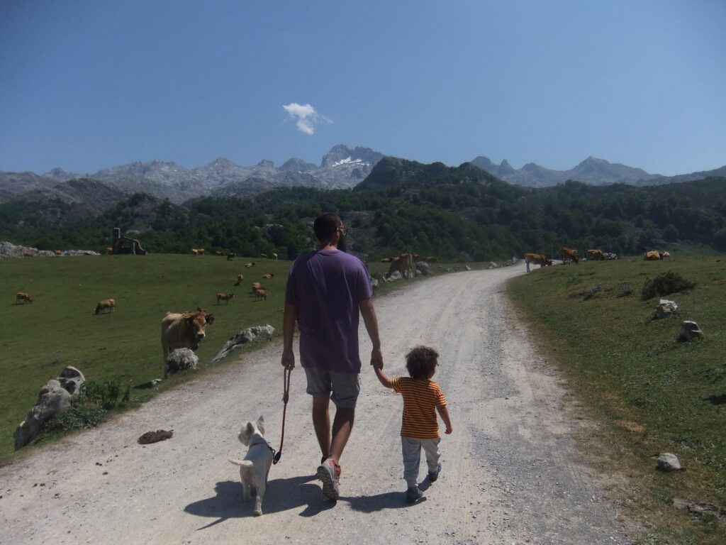 familia con un niño y un perro andando por los lagos de covadonga
