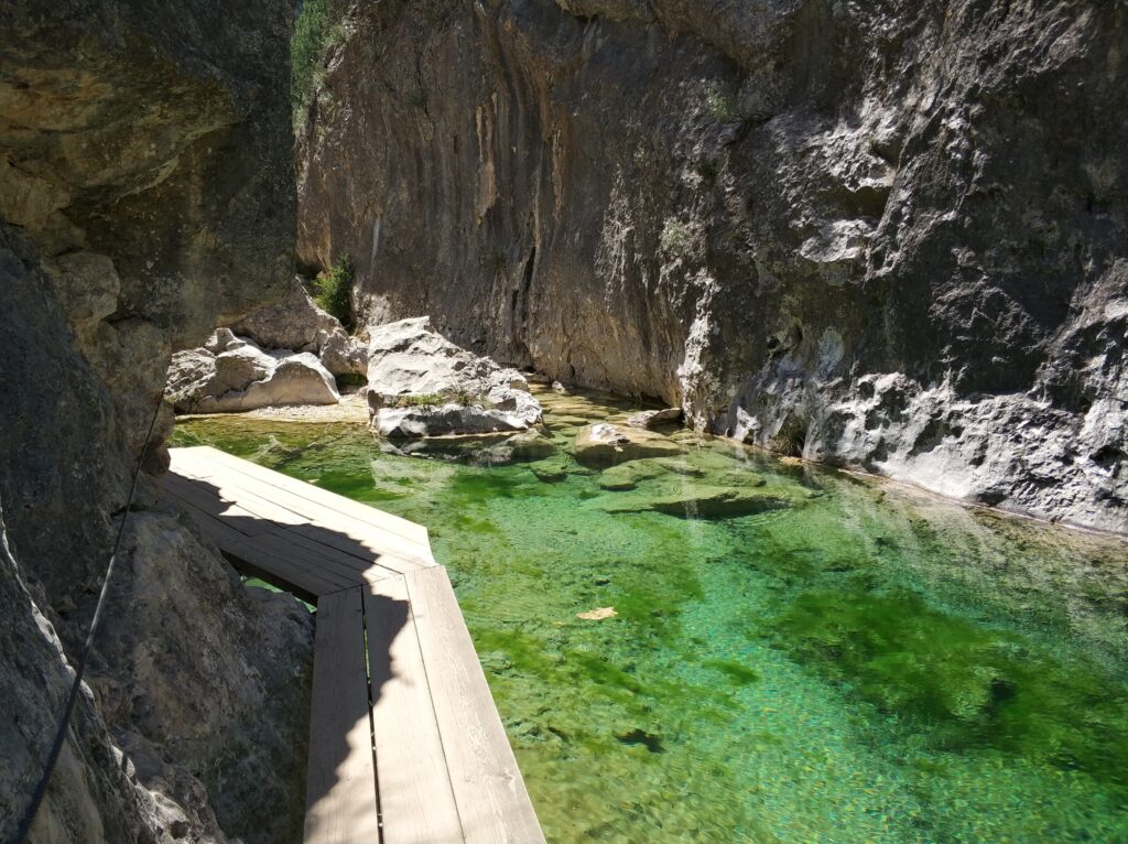 Pasarela de madera sobre poza turquesa en el Parrizal de Beceite, Teruel