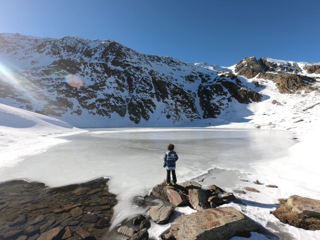 Niño frente al lago congelado de Mascarida en Tavascan