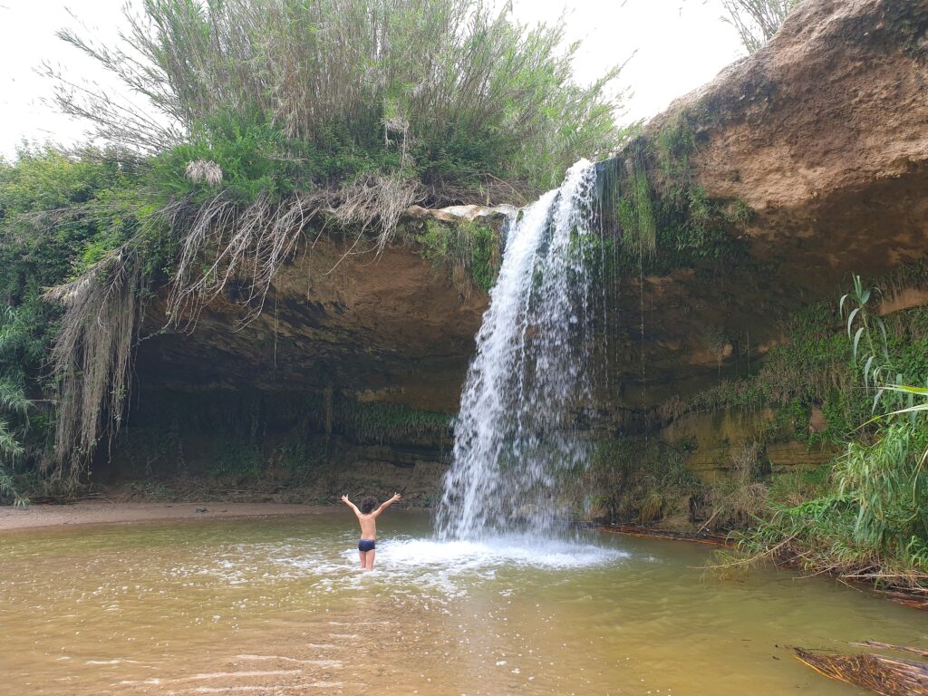 Niño dentro de la cascada de can raimundet