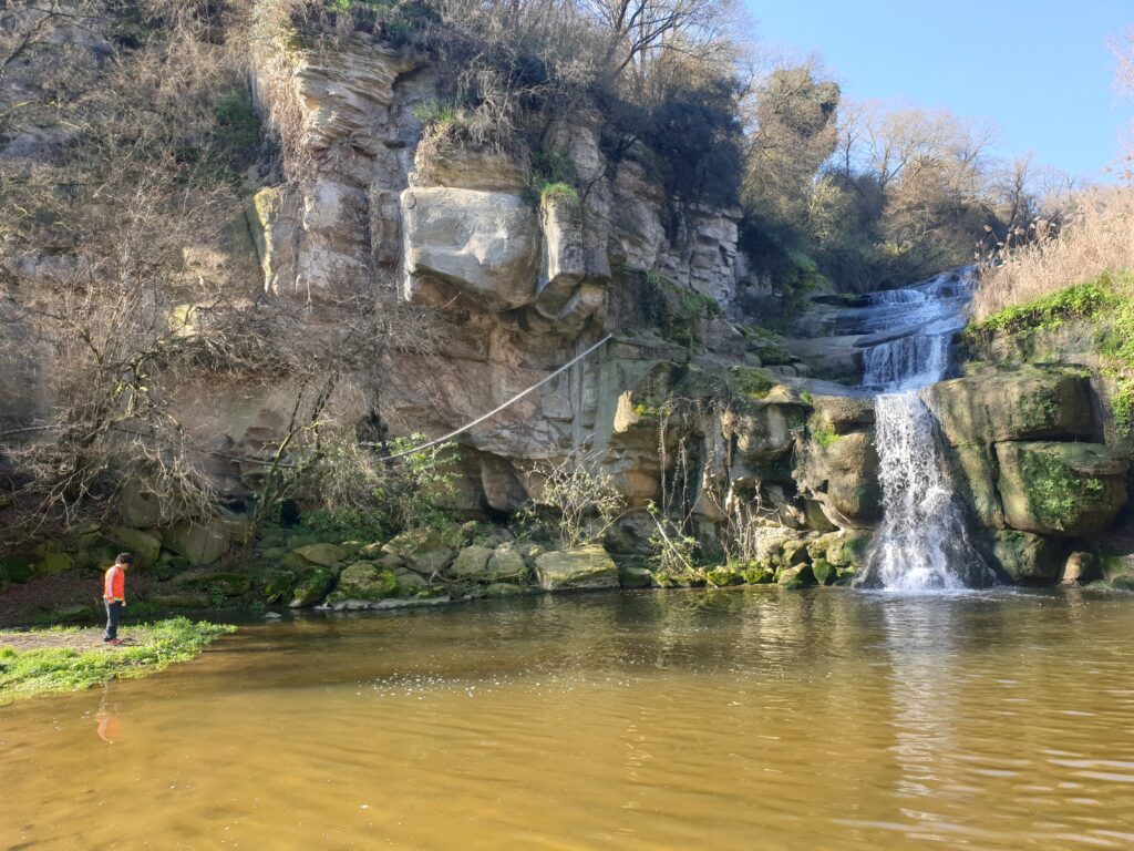 Niño y perrito delante de la cascada Cardona en Osona