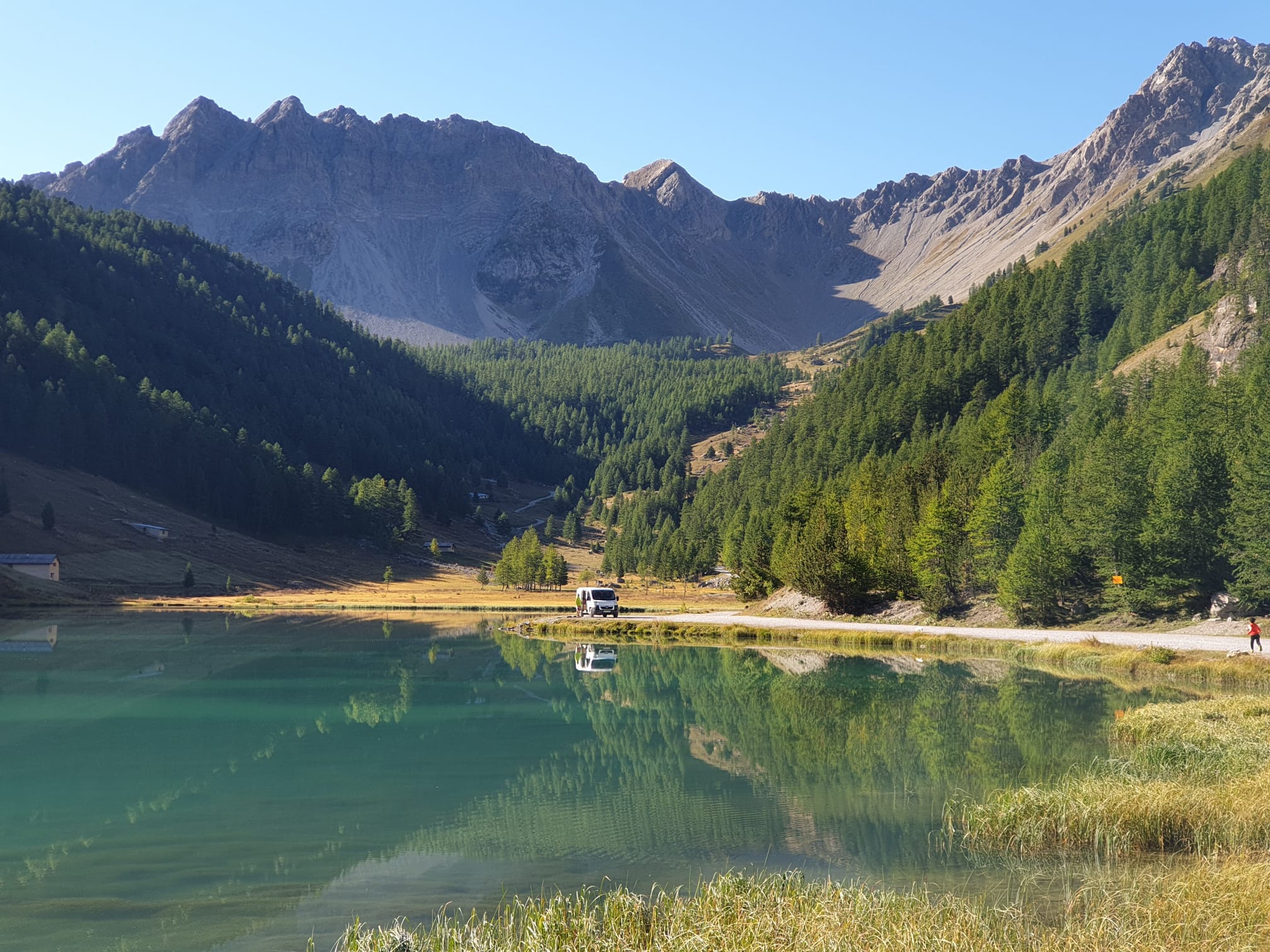 Furgoneta aparcada junto a un lago de montaña en una escapada a la naturaleza