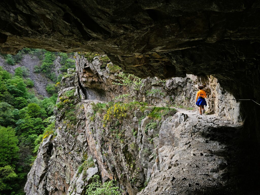 persona transitando por un sendero excavado en la roca, gorges de la caranca, francia