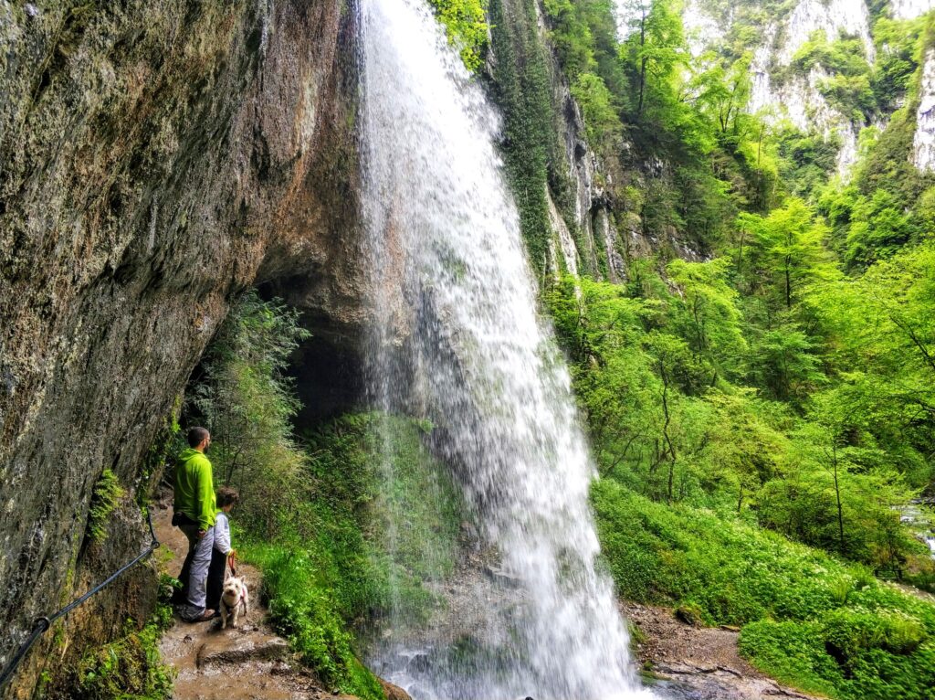 Familia con perra bajo la cascada de 20 metros de las Gorges de Kakuetta, Pirineo vasco francés