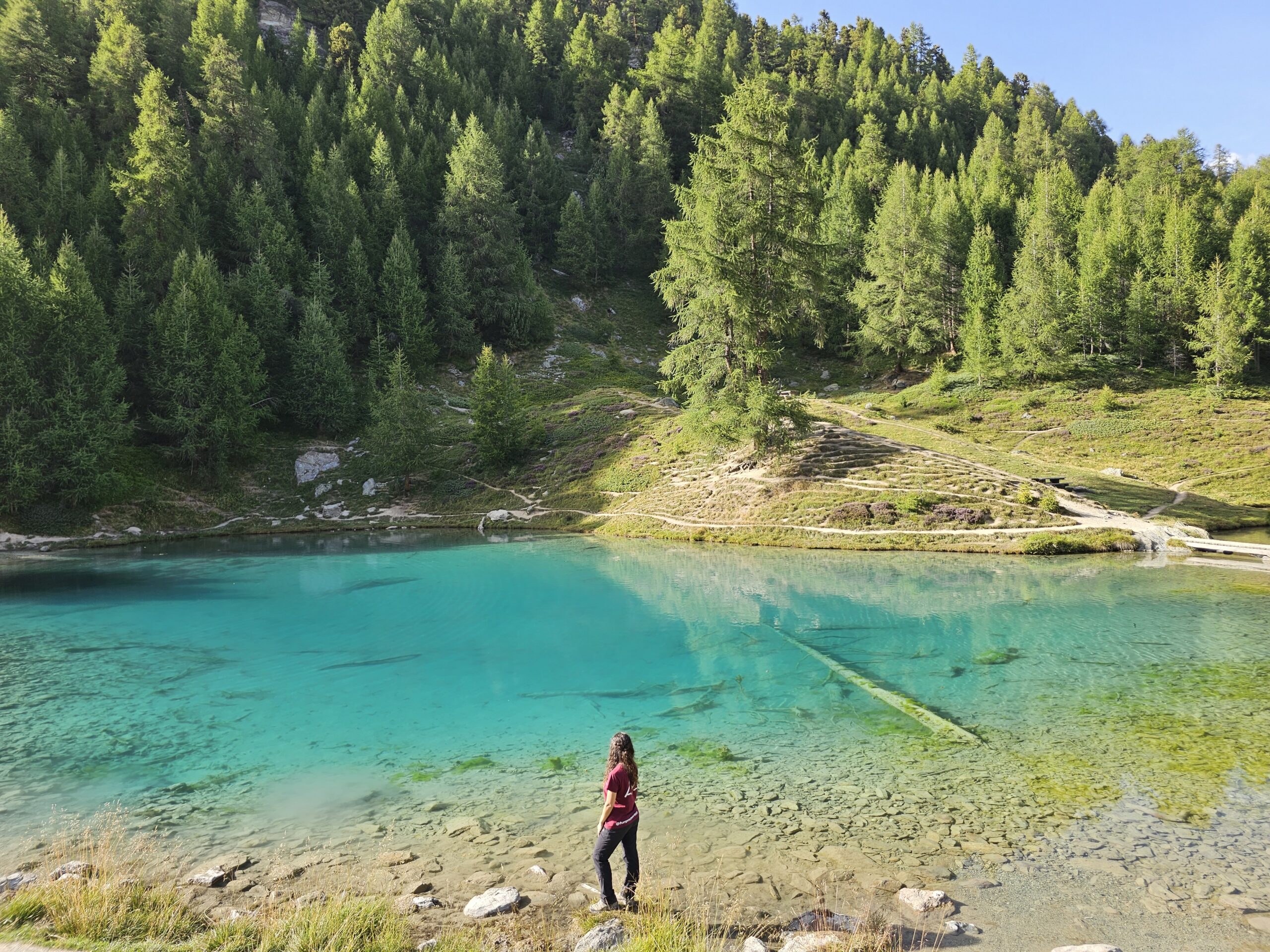 mujer frente a un lago turquesa en Suiza
