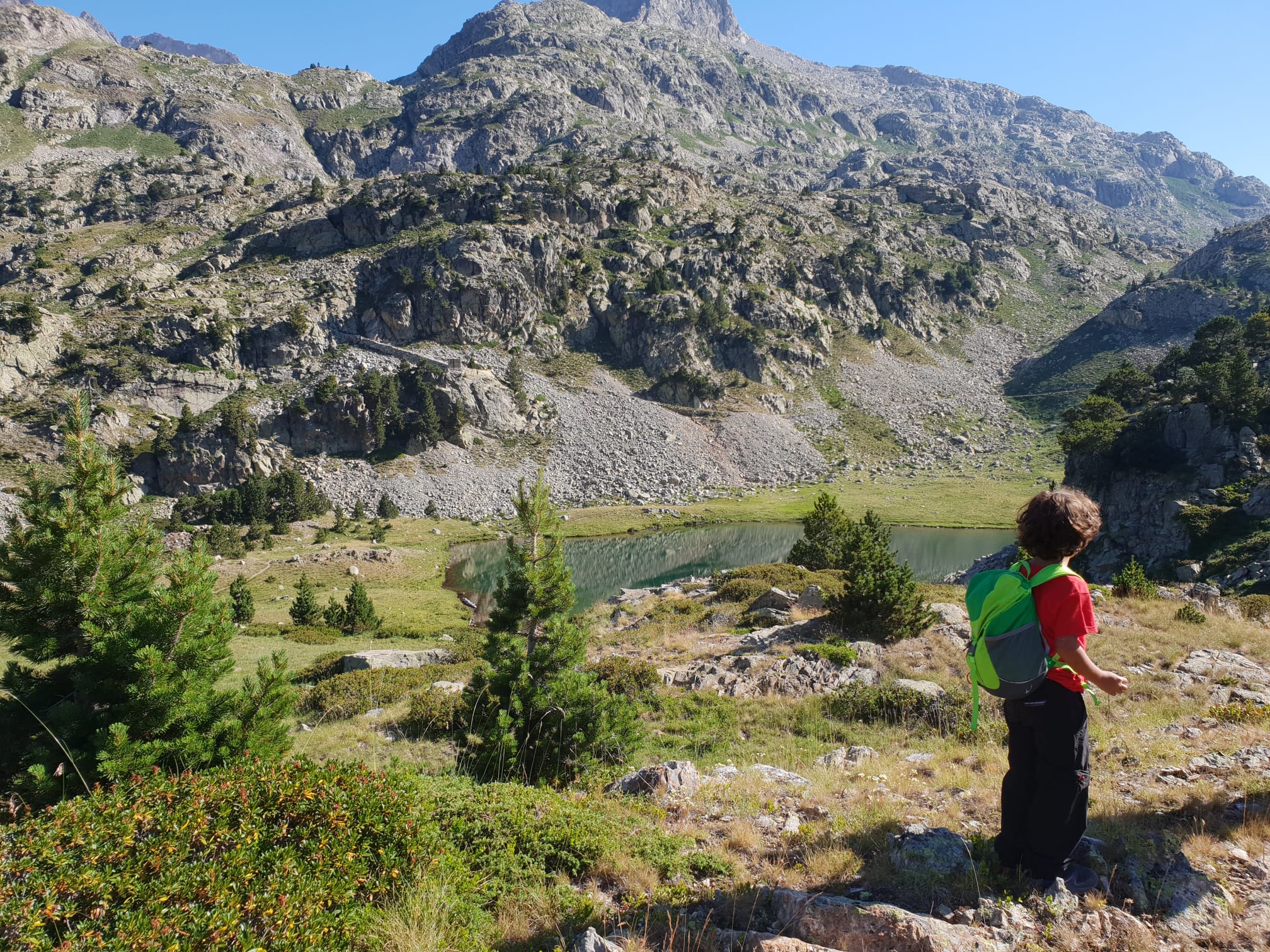 Niño con mochila haciendo senderismo en la montaña