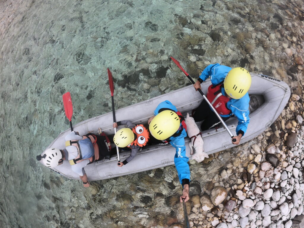 Familia haciendo rafting en el río Soča en Bovec, Eslovenia, con perro a bordo